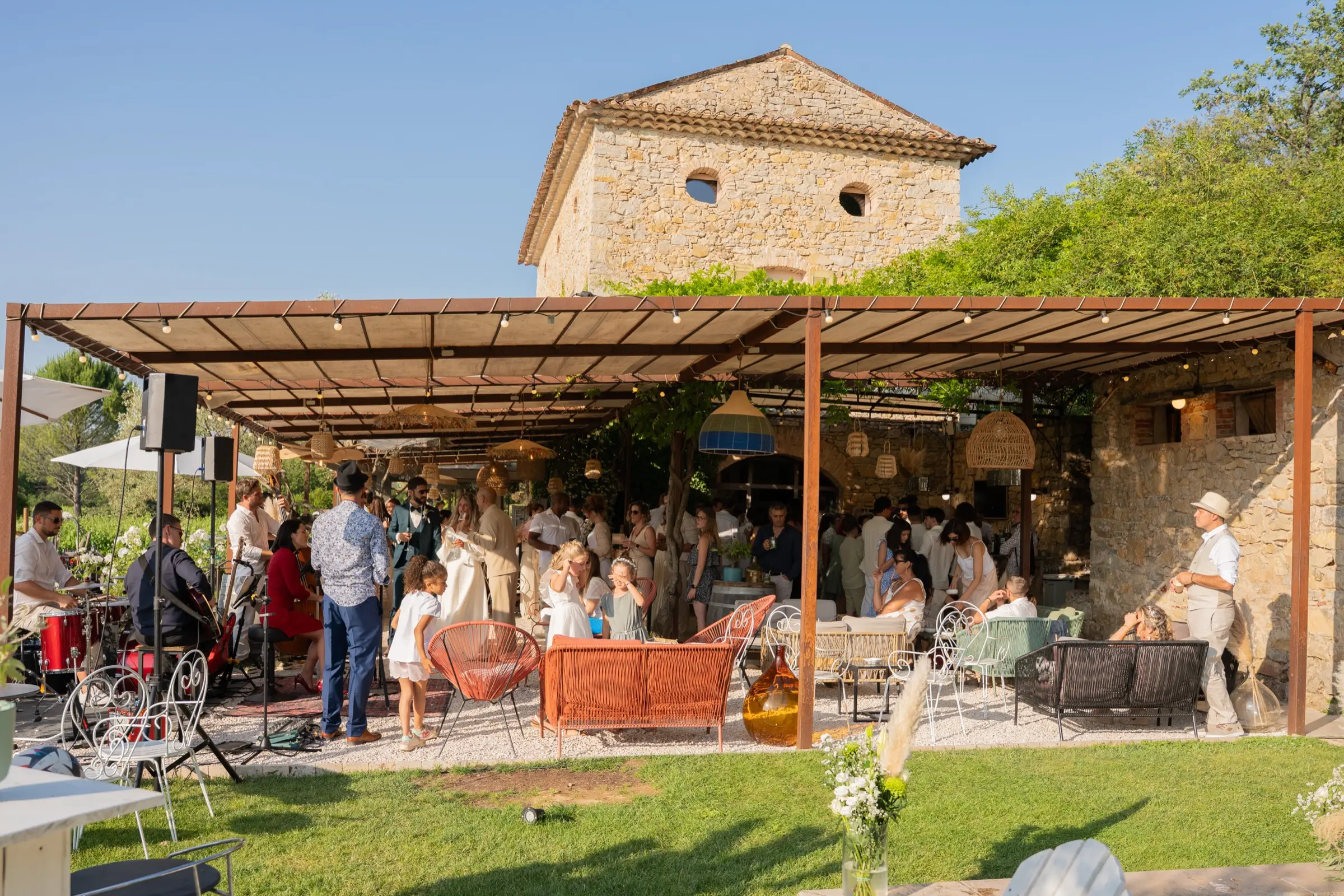 Les invités réunis sous la pergola, au pied de la tour de la bastide