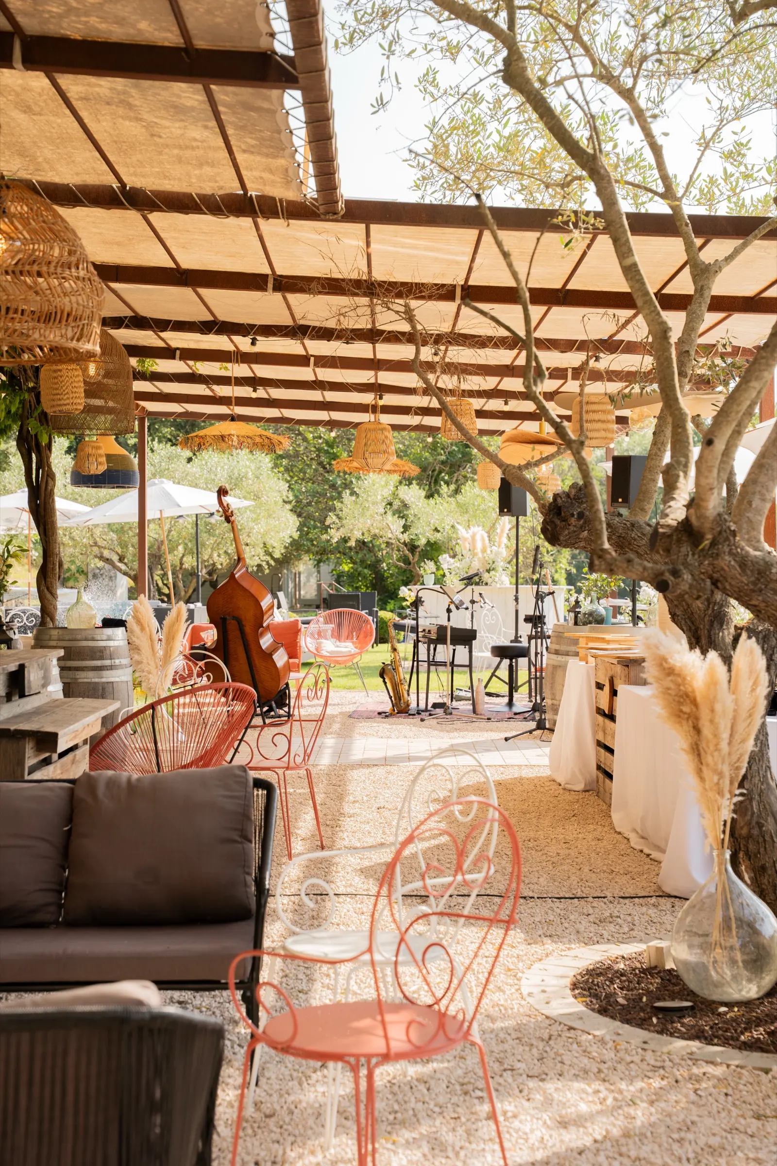 Salons de jardin sous la pergola, à l’ombre d’un grand olivier