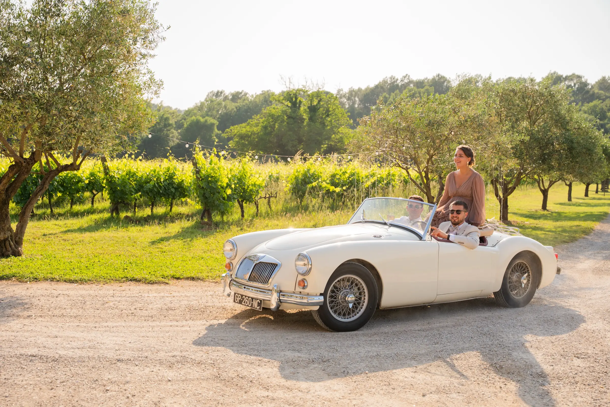 Les mariés arrivent en voiture ancienne au milieu des vignes